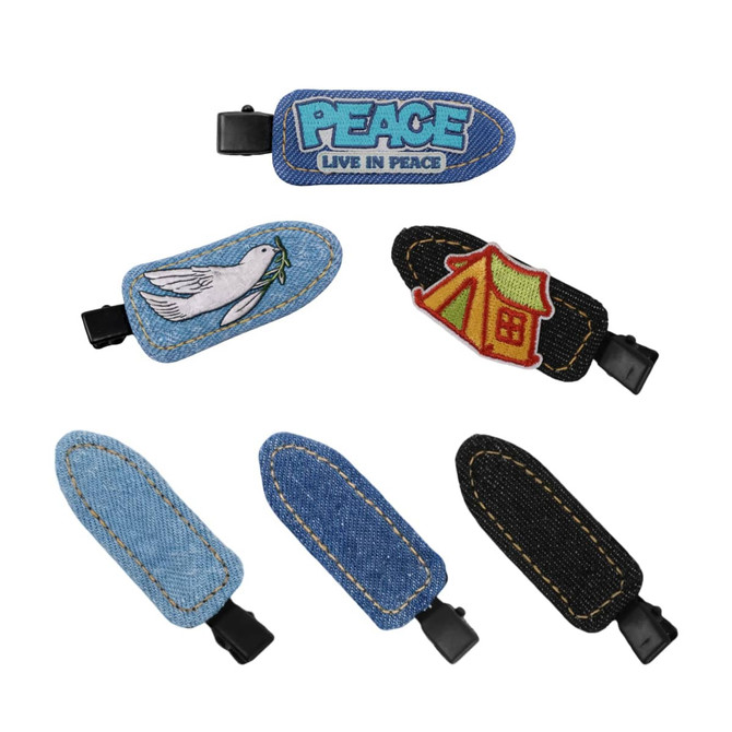 A collection of denim hair clips featuring designs like a dove and a tent, with blue and black denim finishes.