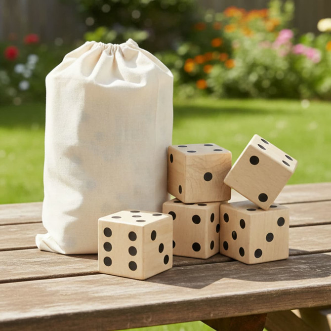 A wooden yard dice set with five large dice and a drawstring canvas bag, set on a wooden table outdoors.