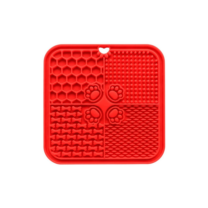 A red, four-section dog enrichment lick mat with various textured patterns, including paw prints and bone shapes.