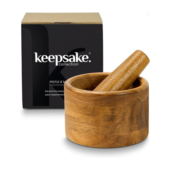 A wooden mortar and pestle set sits beside a black box with a logo, featuring a natural finish.