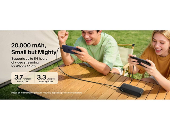 A power bank with integrated cable, featuring a sleek black design. It includes a logo and is placed on a table with two people using phones.