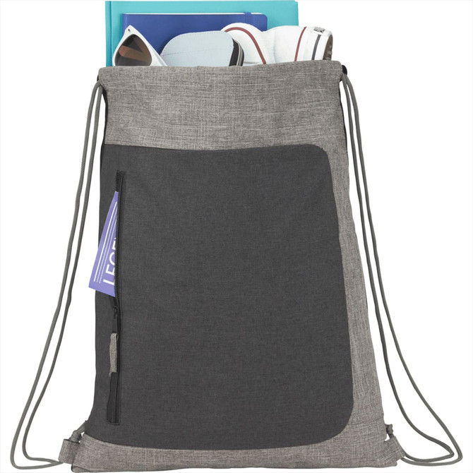 A grey drawstring bag with a front pocket, containing various items, and featuring a logo.