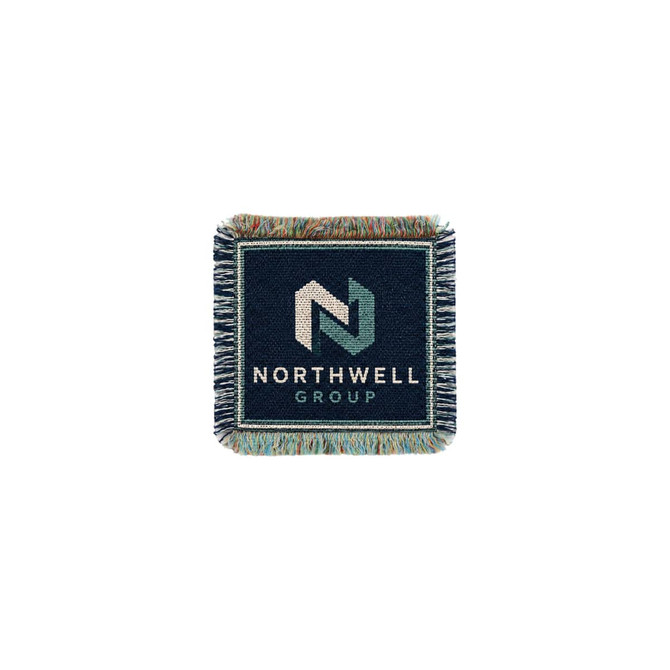 A jacquard coaster in navy blue with a woven logo and fringe detailing around the edges.