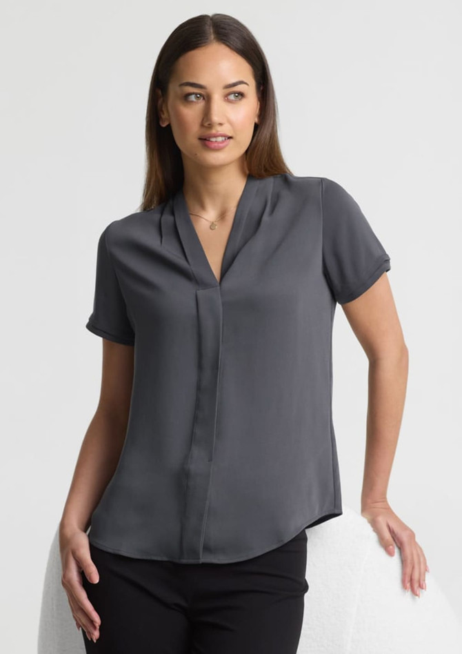 A short-sleeve, button-up shirt in grey, featuring a collared neckline, displayed on a model against a neutral background.