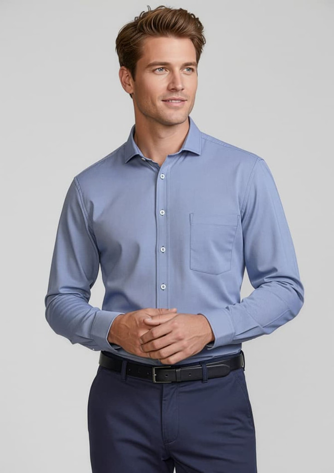 A blue long sleeve button-up shirt with a chest pocket, worn by a smiling man. The shirt features a logo.