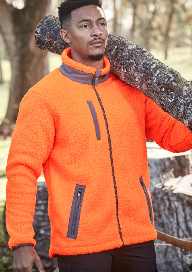 A man wearing an orange unisex full zip Sherpa fleece jacket, carrying a log over his shoulder.