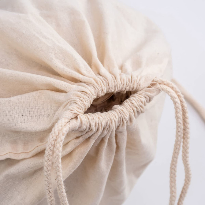 A beige drawstring bag with a gathered opening and matching drawstrings. It has a simple, minimal design.