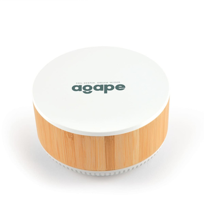 A round speaker and wireless charger in white and bamboo, featuring a logo on the top.