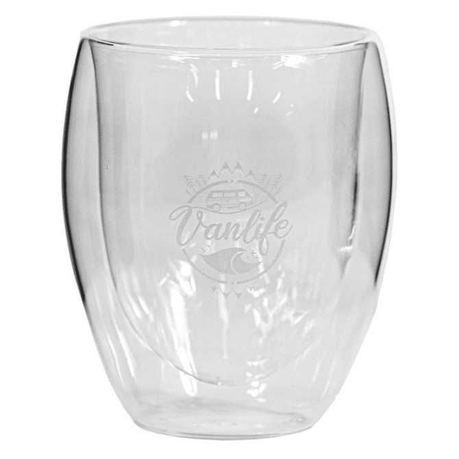 A glass coffee or tea cup with a rounded, transparent design and a logo featuring a van and mountain scene.