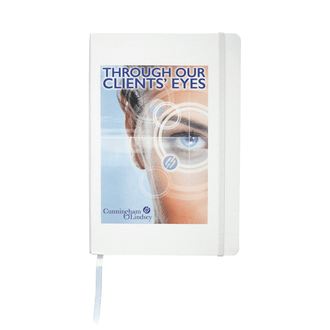 A white journal with a graphic eye design on the cover and an elastic closure. It features a logo.