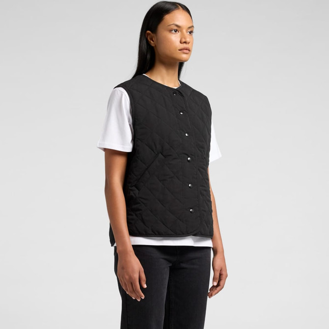 A black quilted vest with buttons, worn over a white T-shirt, displayed on a model. The vest features a logo.