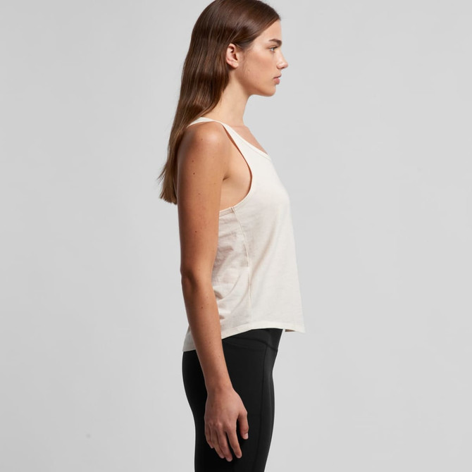 A light beige racerback singlet with a loose fit, featuring a logo on the side. Wellington leggings are worn with it.
