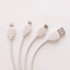 A round-shaped charging cable in white, made from wheat straw, featuring multiple connectors for various devices.