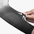 A black and white arm sleeve featuring a gradient design and a logo, highlighted by a hand pulling at the fabric.
