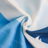 A blue and light blue microfibre beach towel featuring a wave design, showing soft, textured fabric and folds.