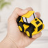 A cartoon bulldozer-shaped stress reliever in yellow and black is being squeezed in a hand. It has a simple design.
