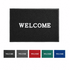 A black welcome mat featuring a white logo, displayed alongside mats in grey, red, blue, and green.