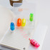 A transparent case containing four highlighters in blue, orange, yellow, and pink, placed on a notepad with lines.