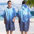 A hooded change towel in blue gradient with a zip, featuring a design on the back and a logo. Suitable for leisure use.