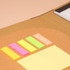 A padfolio featuring a brown exterior, with assorted sticky notes in pink, yellow, green, and orange.