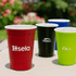 A drink cup set featuring red, green, black, and blue plastic cups, each with a logo on them.