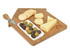 A wooden cheese board shaped like a house, featuring cheese slices, crackers, olives, and a cheese knife.
