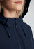 A close-up of a woman wearing a navy blue jacket with a hood, featuring a zip and adjustable drawstrings.