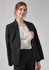 A woman wearing a black blazer over a white blouse, smiling at the camera. The outfit is polished and professional.