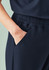 Navy scrub pants featuring an elastic waistband and pockets, with a close-up view of the fabric and design.