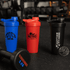 A drink bottle set featuring blue, red, and black shaker cups, each with a logo and a secure lid.
