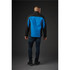 A men's softshell jacket in black and blue, featuring a logo, shown from the back on a model.