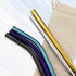 Stainless steel drinking straws in various colours, including gold, black, purple, blue, and silver, with a natural fabric pouch.