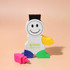 A playful highlighter shaped like a smiling character, featuring a black top and colourful arms, with a pink highlighter cap.