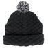 A black knitted beanie with a textured pattern and a black and white pom pom on top. It features a logo.