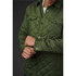 A green quilted jacket with a button-up front and chest pockets, featuring a logo on the upper left.