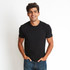 A black men's cotton crew t-shirt displayed on a model, featuring a simple design and tucked hands in pockets.