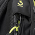 A close-up of a black backpack featuring a clip and anti-thief zipper with contrasting bright yellow accents.