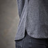 A grey women's polo shirt featuring side slits and a classic design, showcasing textured fabric.