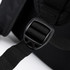 A close-up of a black backpack strap featuring an adjustable buckle and textured fabric.
