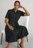 A black midi dress with short sleeves, a button-down front, and a belted waist, displayed on a seated model.