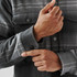 A men's plaid jacket in grey tones with a Sherpa lining, featuring snap buttons on the cuffs.
