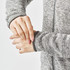 A close-up of a woman's hands adjusting the cuffs of a grey fleece jacket with a full zip.