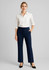 A woman poses in navy adjustable waist pants paired with a white shirt and heels, featuring a logo on the waistband.