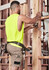 A man wearing khaki cargo shorts and a bright yellow sleeveless top, working with tools on a construction site.