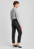 Women’s slim leg pants in dark grey, featuring a sleek design and tailored fit. Styled with a light grey shirt and heels.