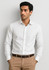 A slim fit long sleeve white button-up shirt worn with tan trousers. The shirt features a collar and has a logo.