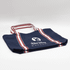 A navy canvas tote bag with red and white stripes and a logo. It has two sturdy handles for carrying.