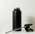 A drink bottle in matte black, featuring a removable lid and a stainless steel straw. It has a logo on the side.