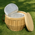 A wicker cooler basket in a natural tone with a pale lid, featuring a silver insulated interior.