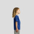 A side view of a child wearing a blue T-shirt, paired with grey shorts. The shirt has a logo on it.